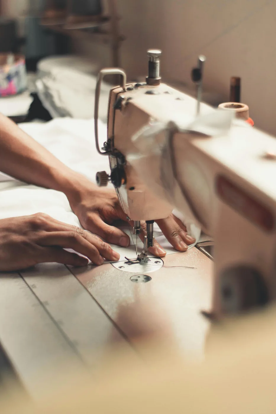 Hands guiding fabric through a sewing machine