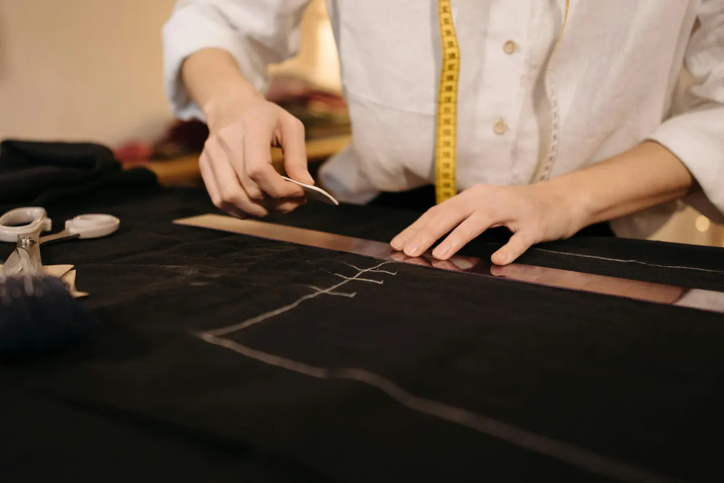 A pattern being measured and marked on dark fabric